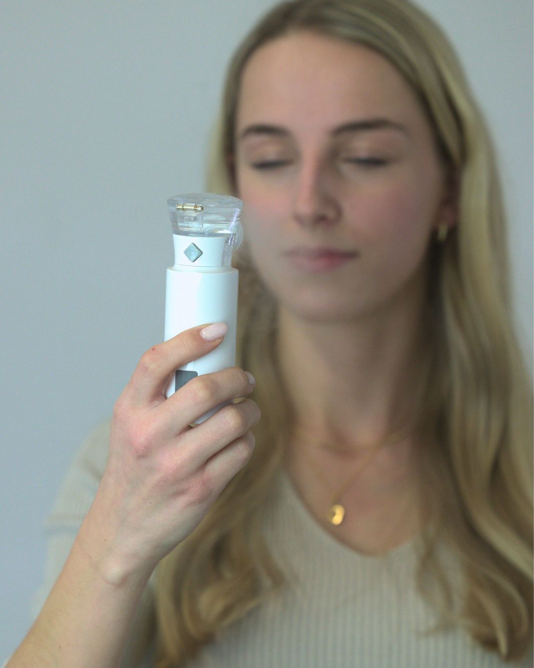 Frau inhaliert mit dem OxygenOne Taschenvernebler die OXYGEN Sole