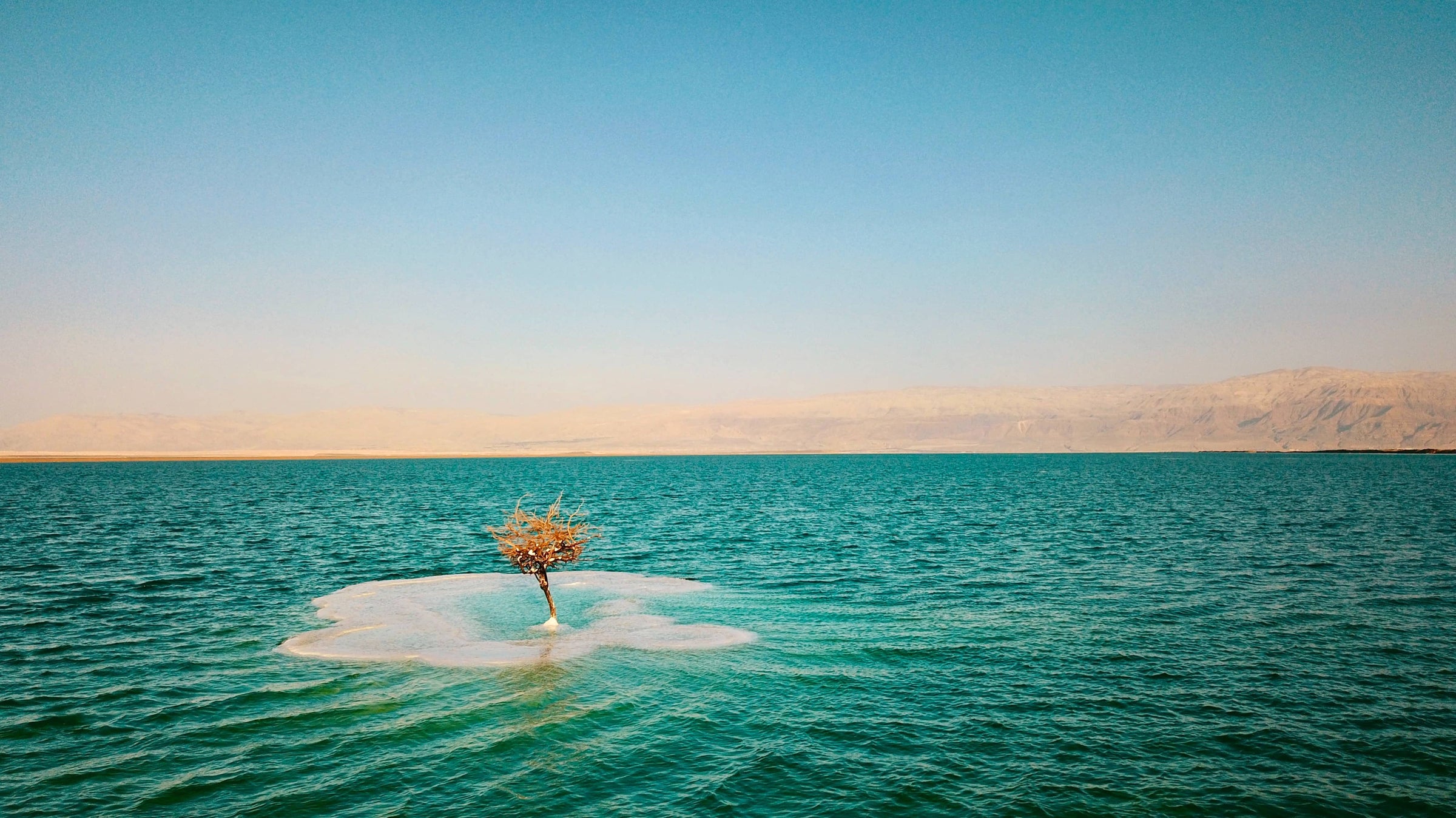 Eine kleine Insel umgeben von türkisen Wasser 